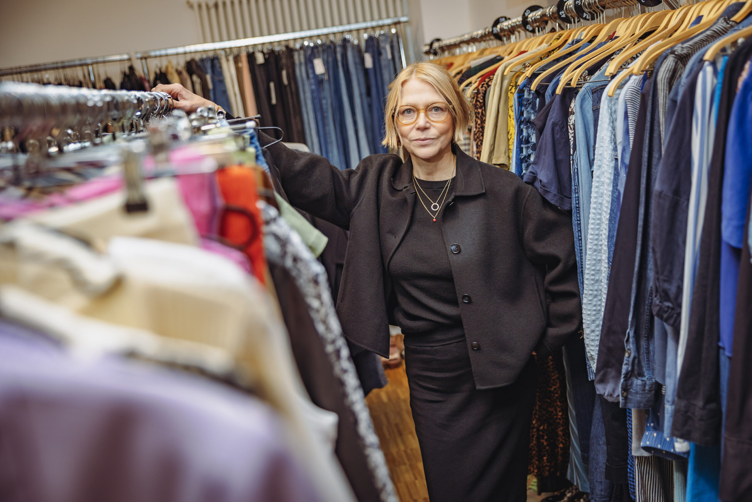 Britta Falk (54) steht in ihrem Laden „Second Schanze“ zwischen Kleiderstangen