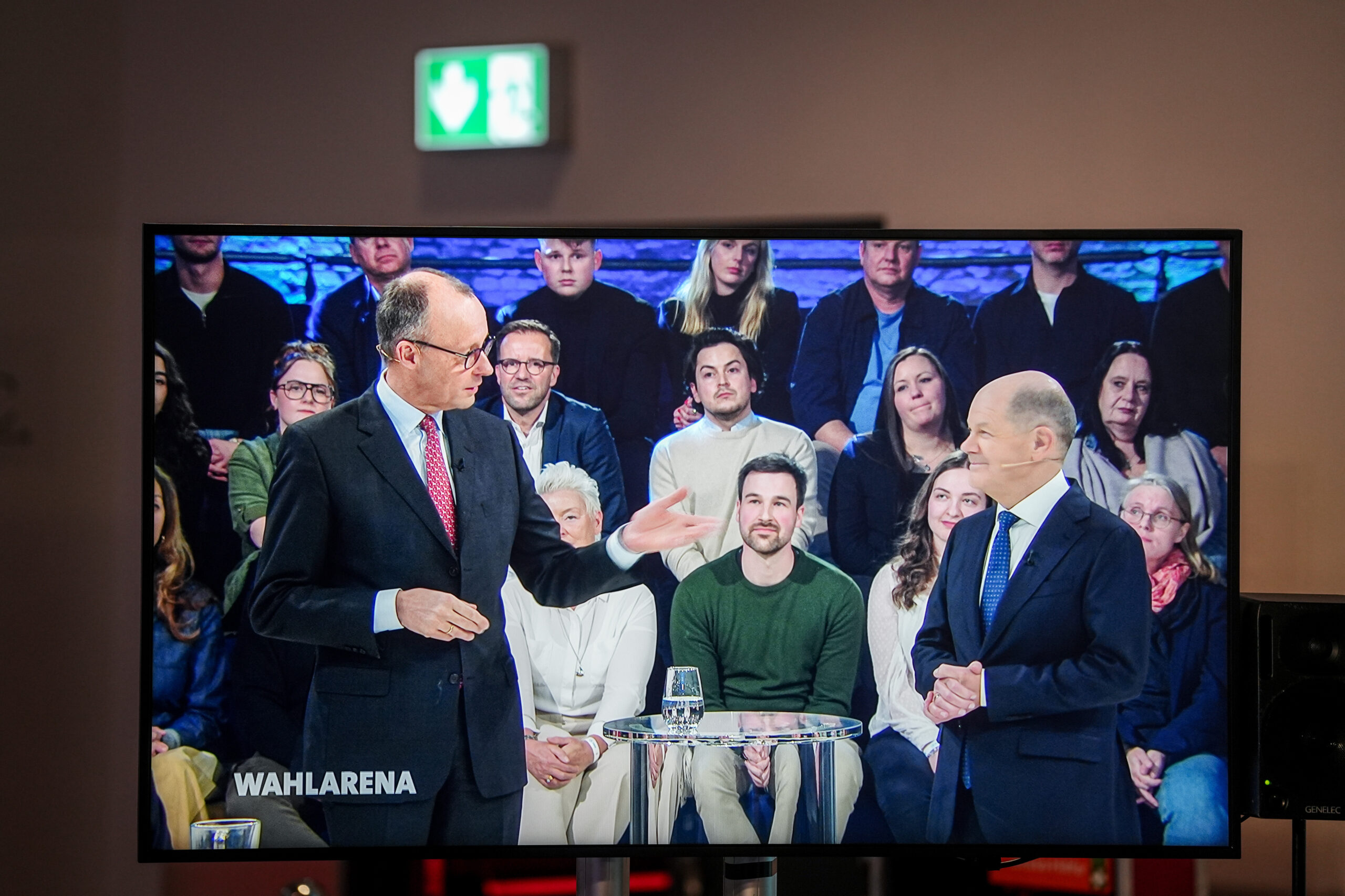 Friedrich Merz und Olaf Scholz auf einem TV-Gerät während einer Wahlsendung