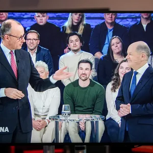 Friedrich Merz und Olaf Scholz auf einem TV-Gerät während einer Wahlsendung