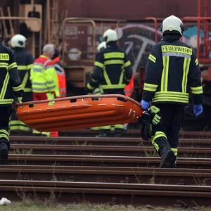 Retter im Rostocker Überseehafen auf dem Weg zu dem Waggon, auf dem die Leiche gefunden wurde.