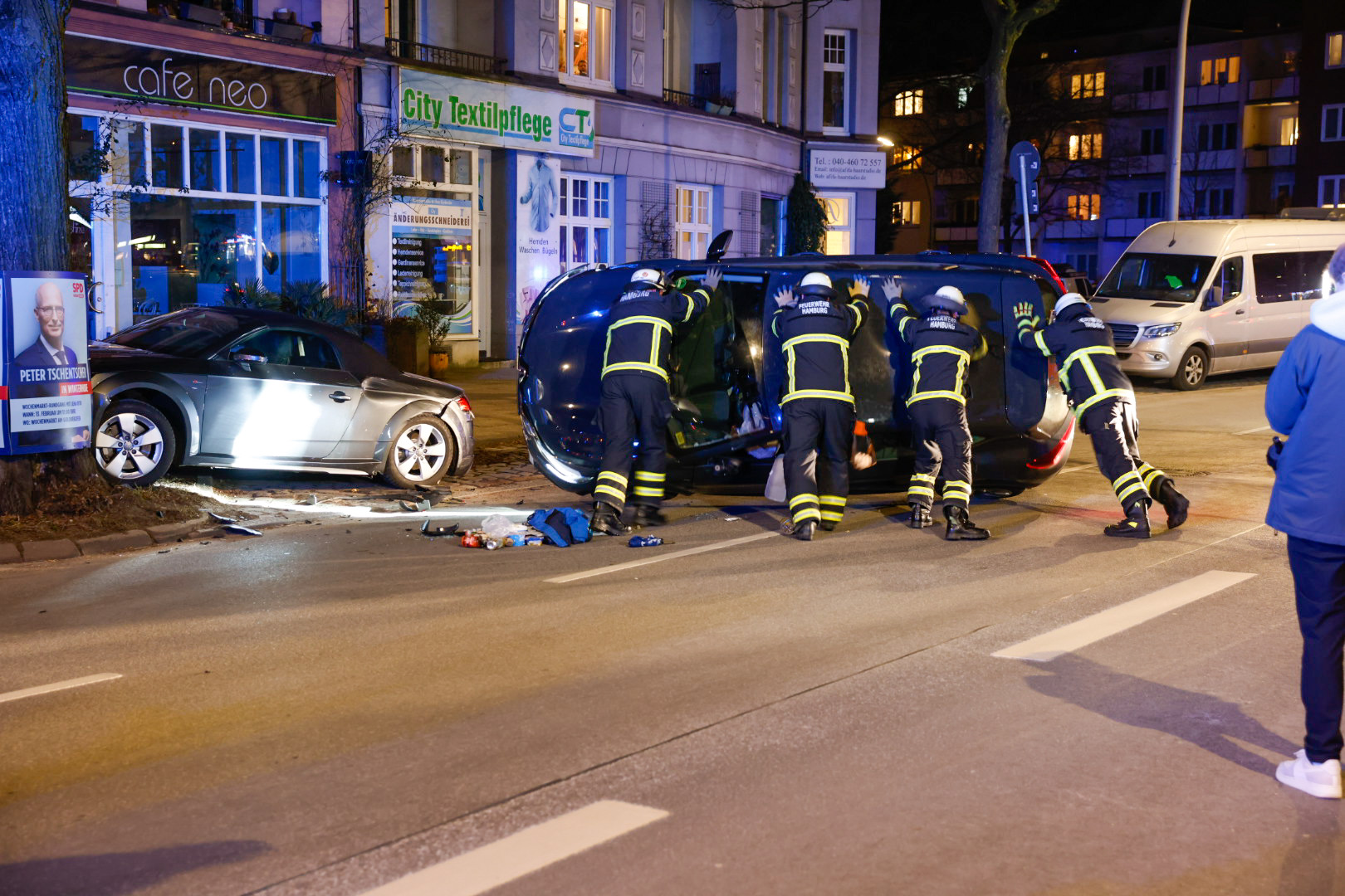 Einsatzkräfte der Feuerwehr richten das umgekippte Unfall-Fahrzeug wieder auf.
