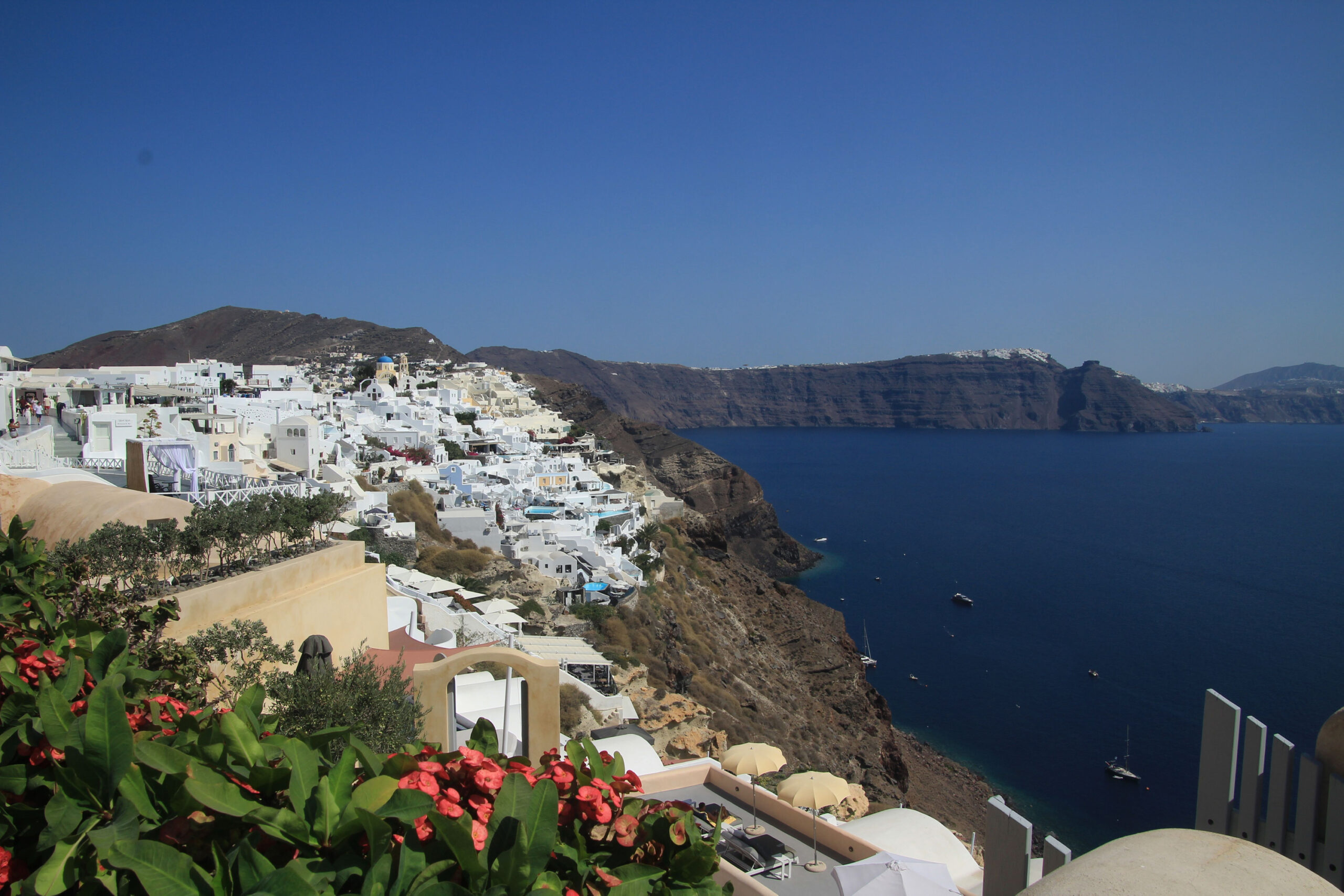 Viele weiße Häuser liegen an der Küste von der griechischen Insel Santorini