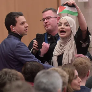 Eine Besucherin einer Wahlkampfveranstaltung von Olaf Scholz (SPD) in Hannover wird nach Zwischenrufen aus dem Saal geleitet.