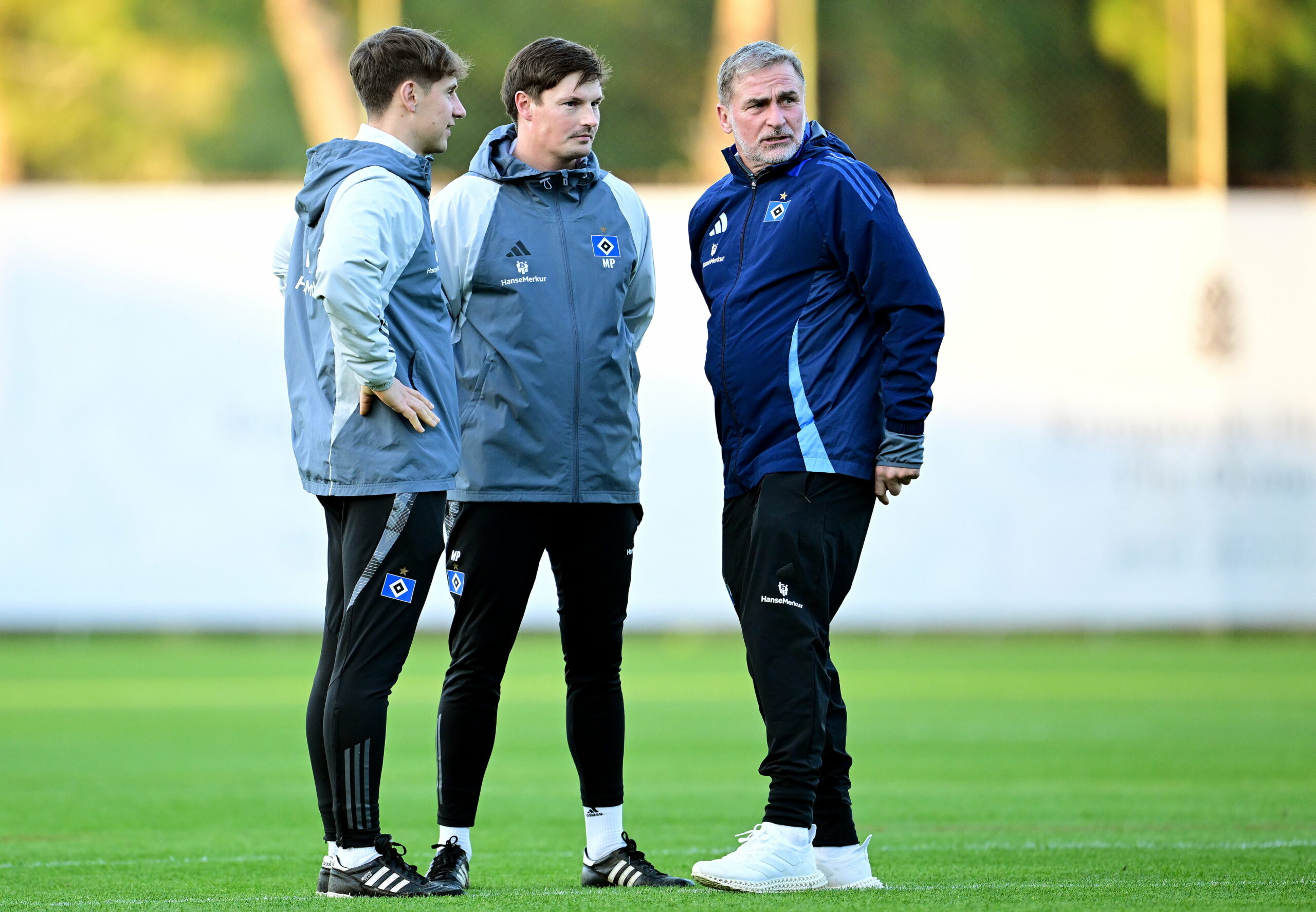 Stefan Kuntz im Gespräch mit den HSV-Trainern Loic Favé und Merlin Polzin auf dem Trainingsplatz