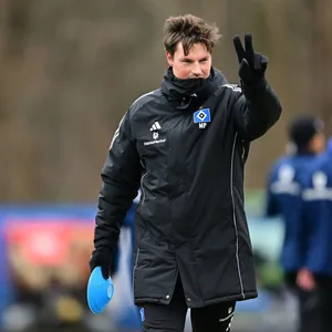 Merlin Polzin zeigt mit seinen Fingern eine zwei an im HSV-Training.