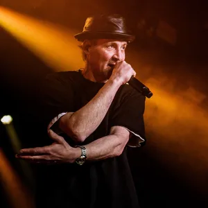 Mann mit Hut rappt in ein Mikrofon