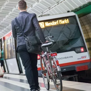 Ein Mann steht mit seinem Fahrrad an einem U-Bahnsteig in Hamburg.