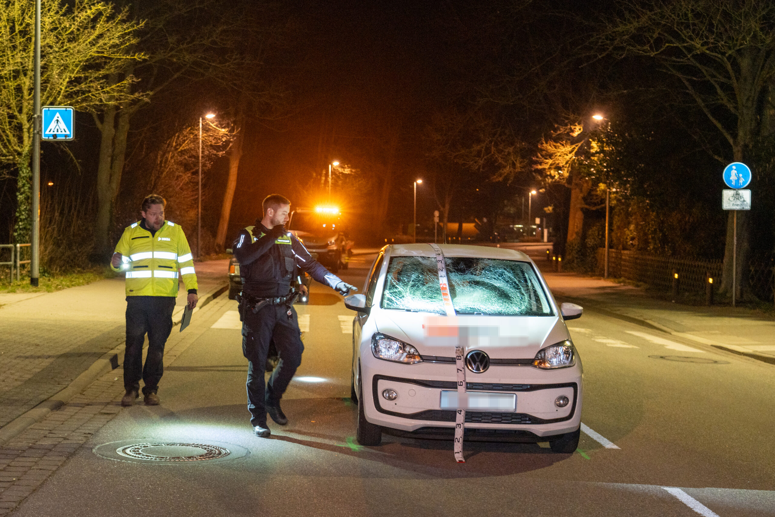 Die Polizei und ein Sachverständiger sichern Spuren am Unfallwagen.