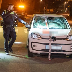 Die Polizei und ein Sachverständiger sichern Spuren am Unfallwagen.