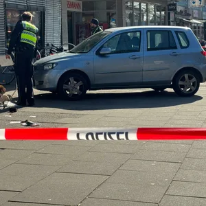 Eine abgesperrte Unfallstelle vor einem Supermarkt