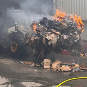Mit einem Bulldozer wurden abgebrannte Papierhaufen zusammengefahren.