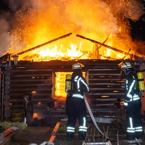 Feuerwehrkräfte löschen die Flammen. Die Laube brannte komplett nieder.