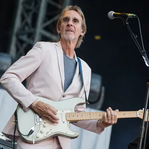 Mike Rutherford spielt auf der Bühne Gitarre.