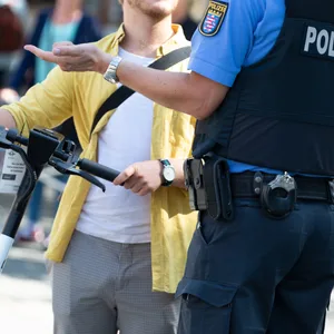 Ein E-Scooter-Fahrer in einer Polizeikontrolle (Symbolbild).