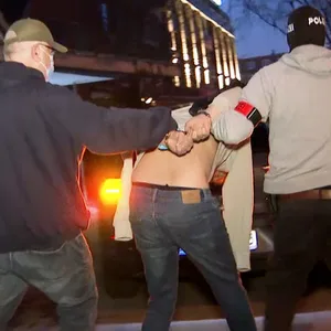 Ein Mann wird in Handschellen abgeführt