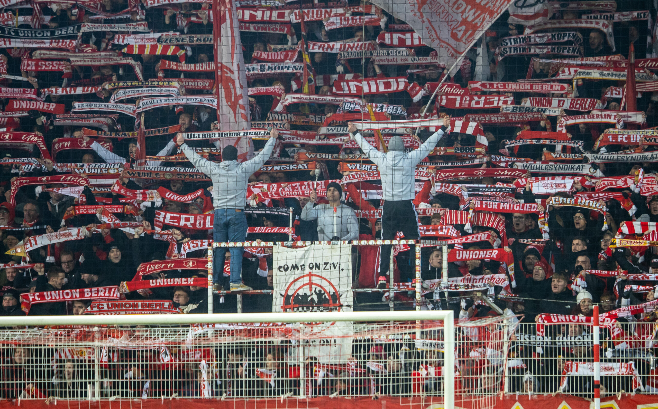 Fans von Union Berlin halten ihre Schals hoch