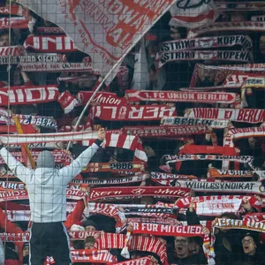 Fans von Union Berlin halten ihre Schals hoch