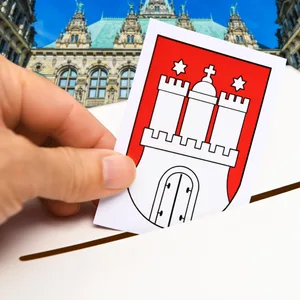 Stimmzettel mit Hamburg-Wappen wird in eine Wahlurne geworfen, Symbolfoto Bürgerschaftswahl in Hamburg, Fotomontage