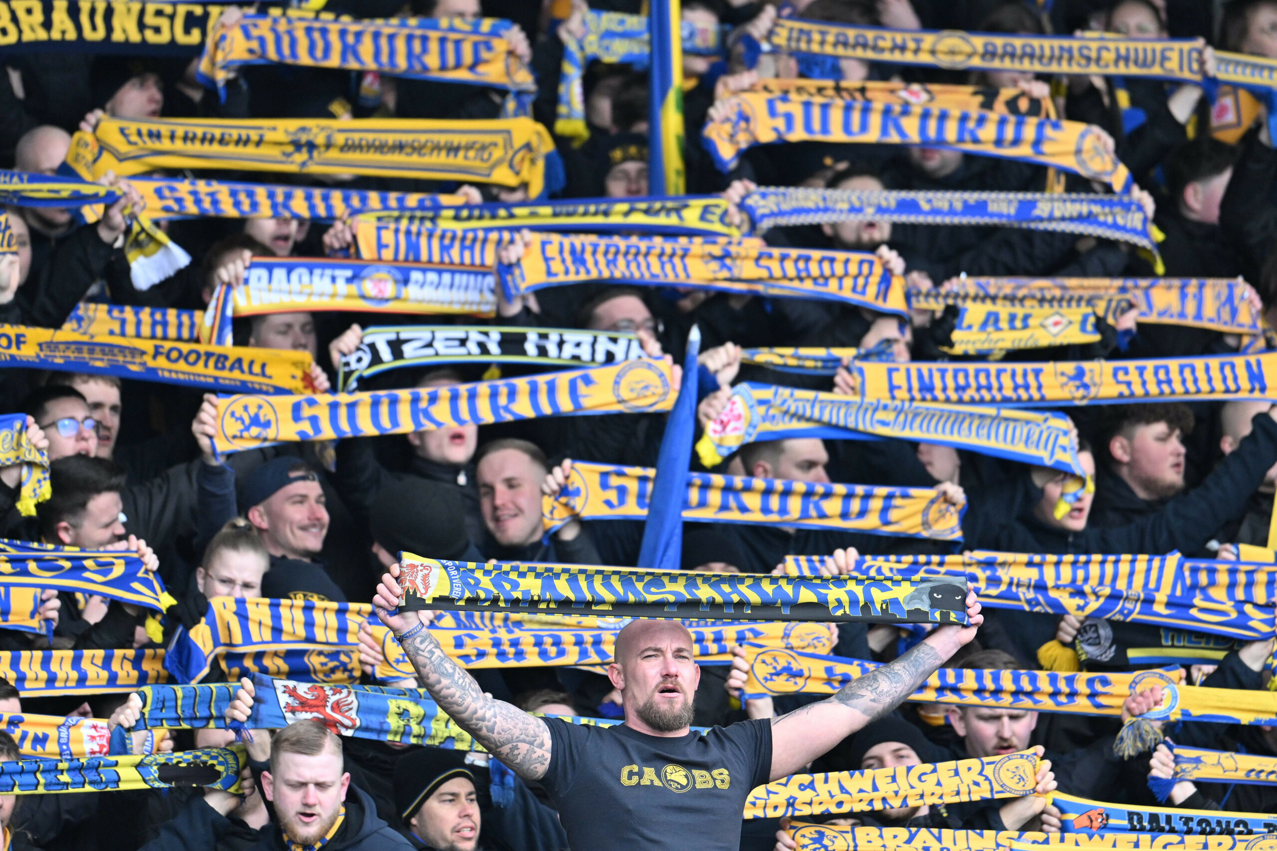 Braunschweig-Fans halten ihre Schals hoch