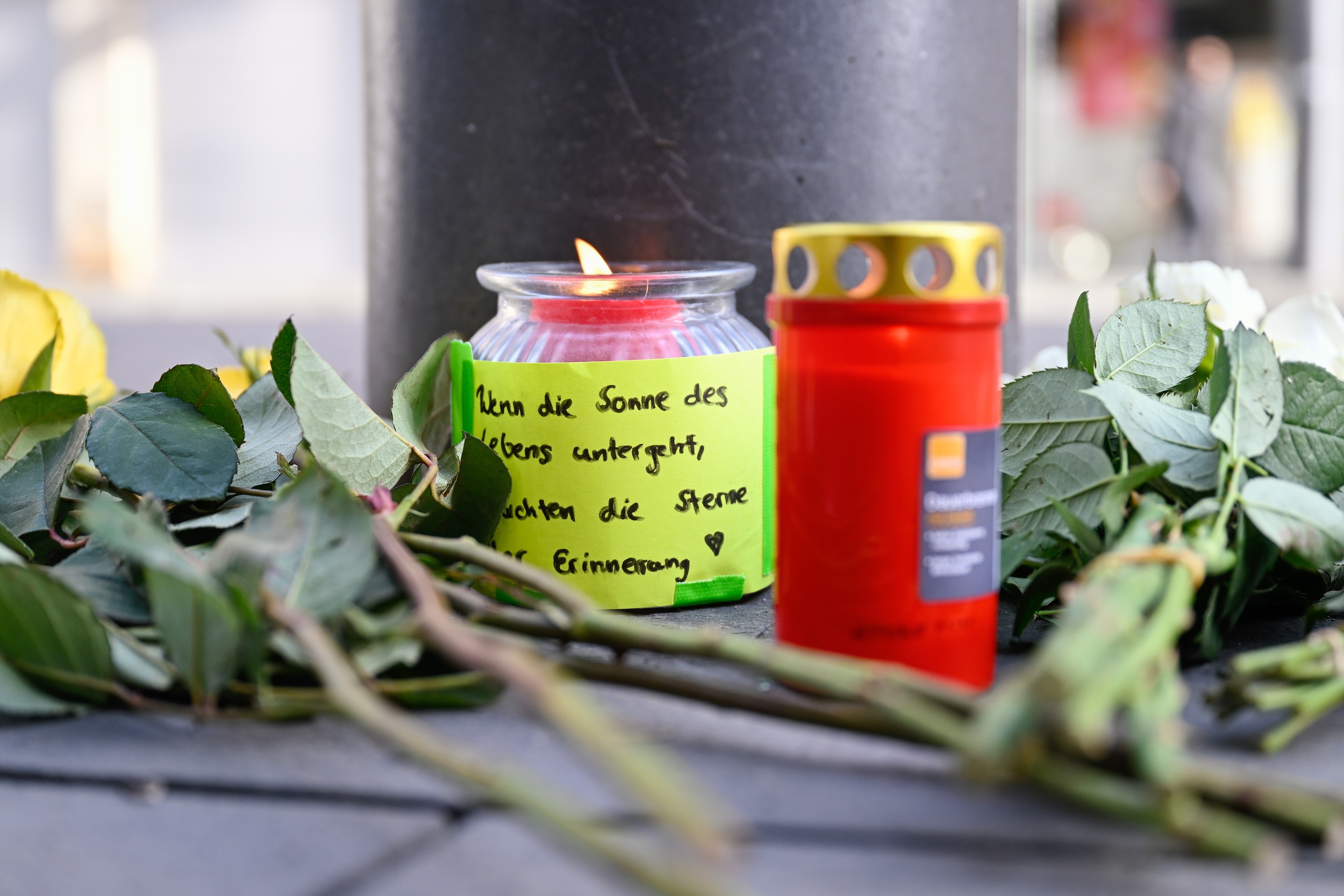 Kerzen und Blumen liegen in der Nähe des Paradeplatzes an einer S-Bahn-Haltestelle. Am Vortag war ein Auto in eine Menschenmenge gefahren. Zwei Menschen starben, weitere wurden verletzt.