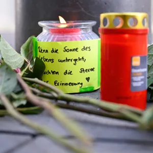 Kerzen und Blumen liegen in der Nähe des Paradeplatzes an einer S-Bahn-Haltestelle. Am Vortag war ein Auto in eine Menschenmenge gefahren. Zwei Menschen starben, weitere wurden verletzt.