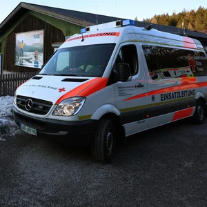 Ein Einsatzfahrzeug des Roten Kreuzes steht am Ufer des Eibsees, nahe der Stelle, an der am Donnerstag mehrere Menschen im Eis eingebrochen waren.