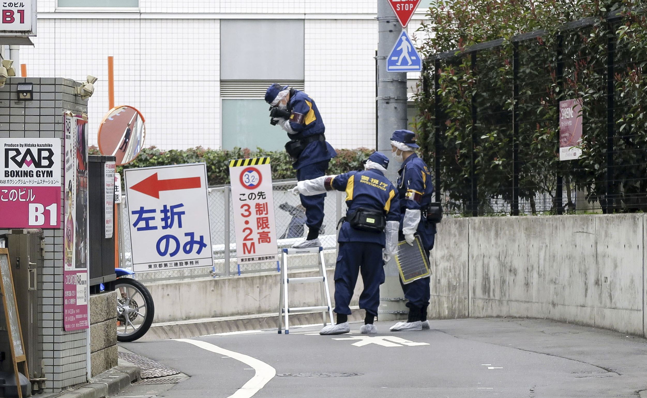 Japanische Polizeiermittler arbeiten in der Nähe des Tatorts nachdem eine Frau in Tokio während eines Live-Streams auf offener Straße niedergestochen wurde.