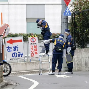 Japanische Polizeiermittler arbeiten in der Nähe des Tatorts nachdem eine Frau in Tokio während eines Live-Streams auf offener Straße niedergestochen wurde.