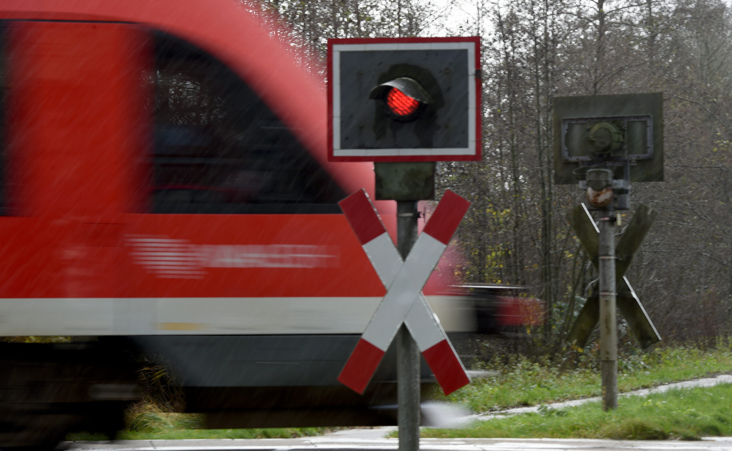 Ein Zug fährt über einen unbeschrankten Bahnübergang.