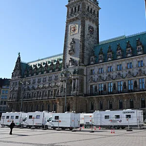 Fahrzeuge und Trailer einer Filmproduktion stehen auf dem Rathausplatz vor dem Rathaus