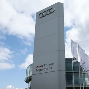 Dunkle Wolken sind hinter Fahnen mit dem Logo von Audi vor dem Audi-Forum zu sehen.