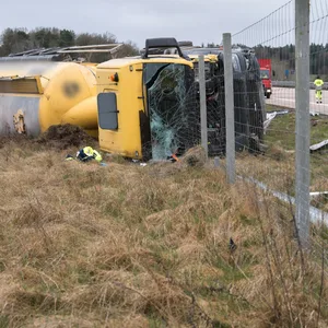 Unfall auf der A7: Ein gelber LKW liegt auf die Seite gekippt, am Rand der Autobahn