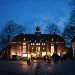 Besucher gehen am 09.04.2016 während der "Langen Nacht der Museen" in Hamburg auf das Hamburg Museum zu, das in der blauen Stunde angestrahlt wird.