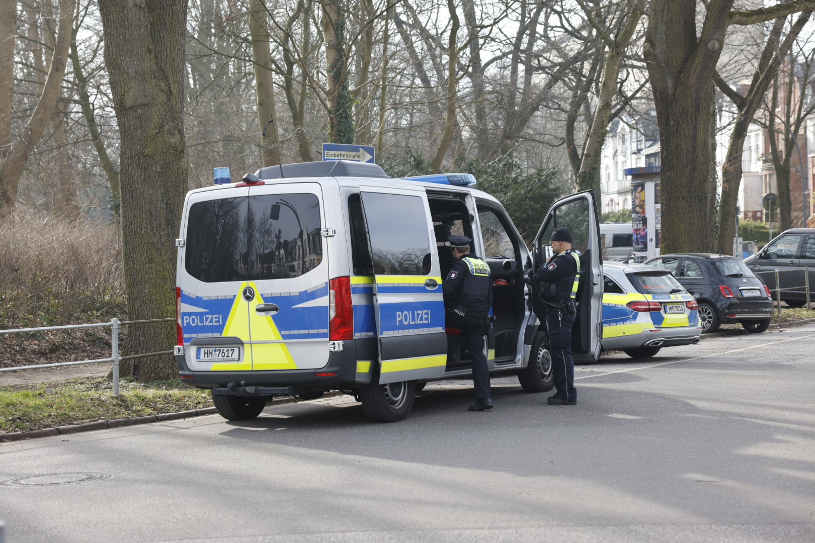 Bewaffnete Polizisten vor einem Polizeitransporter