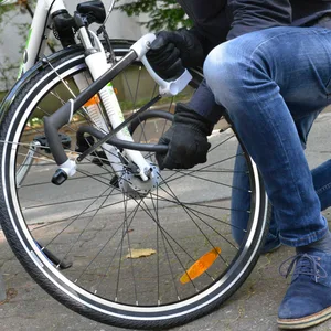 Ein Fahrraddieb schneidet ein Schloss mit einer Säge auf
