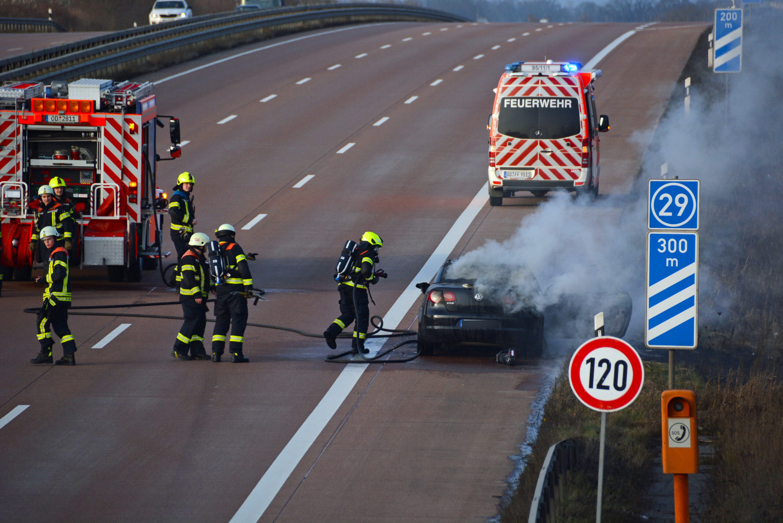 Die Feuerwehr löscht den brennenden VW,