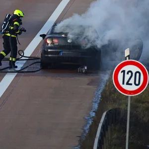 Die Feuerwehr löscht den brennenden VW,
