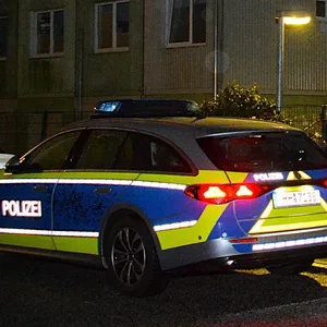 Polizeiautos vor Wohncontainern