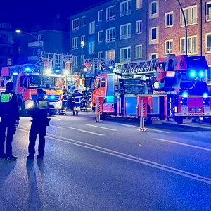 Leiterwagen der Feuerwehr vor Mehrfamilienhaus
