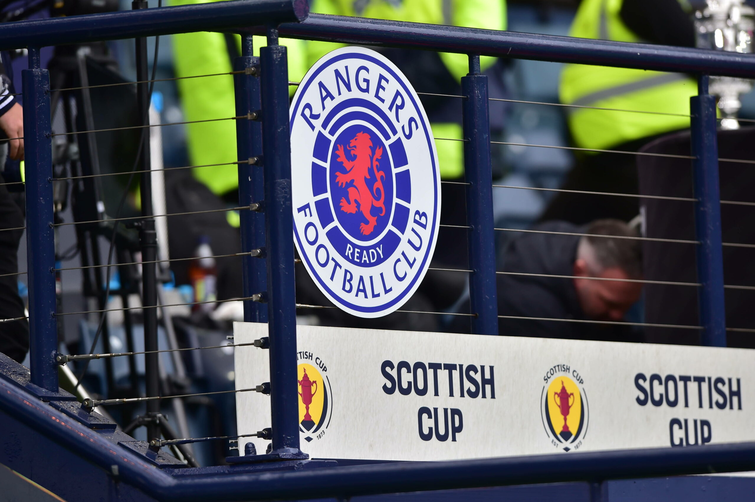 Das Logo der Glasgow Rangers vor einem Tribünen-Zaun