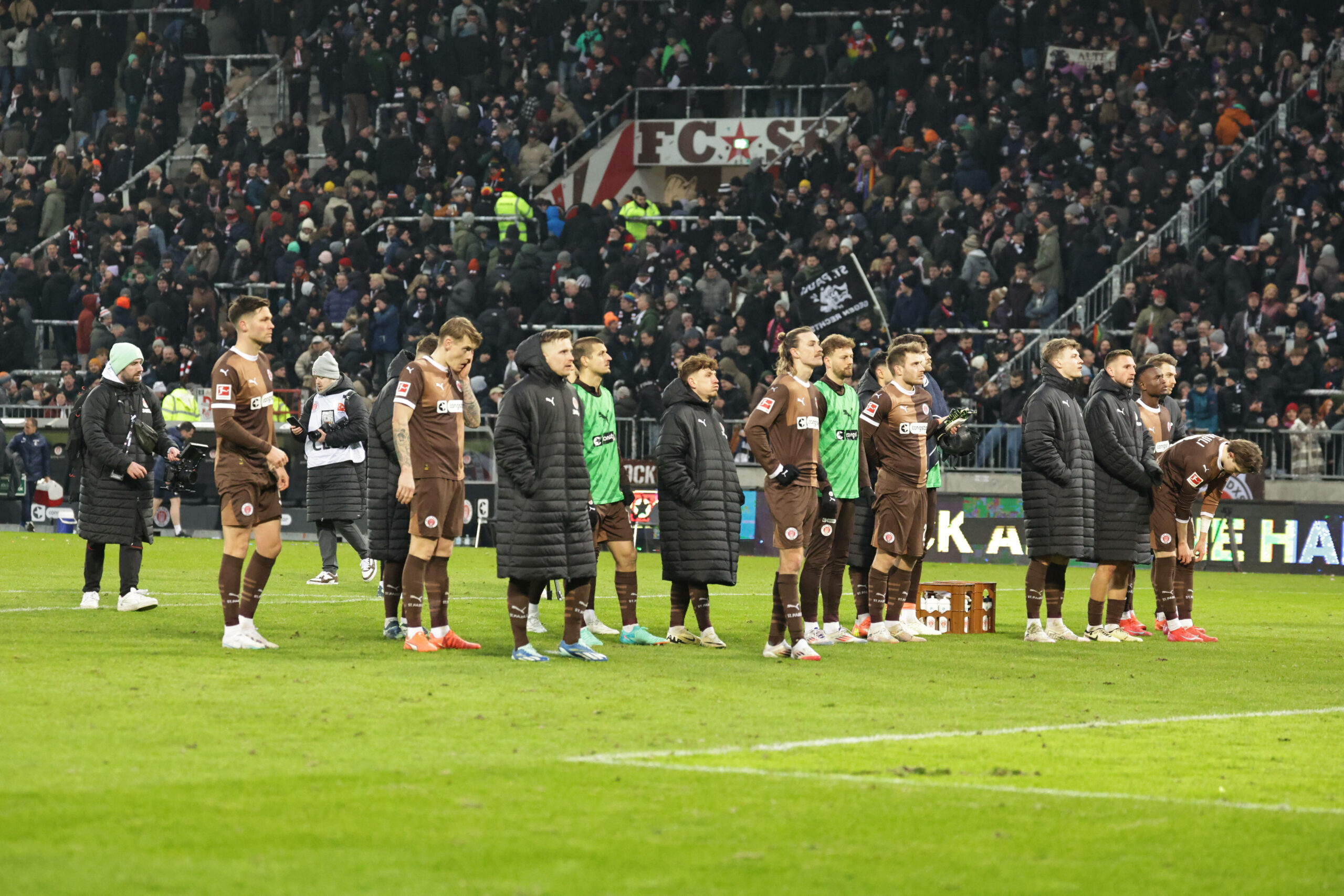 St. Paulis Spieler stehen enttäuscht vor der Kurve