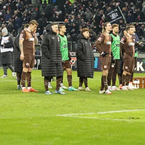 St. Paulis Spieler stehen enttäuscht vor der Kurve