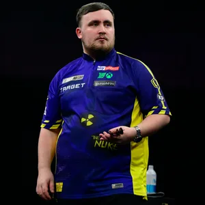 Luke Littler hält seine Darts-Pfeile in der Hand