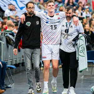 Dominik Axmann muss nach seiner Verletzung gestützt von zwei Betreuern vom Feld getragen werden.