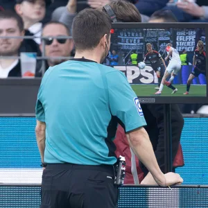 Schiedsrichter schaut sich eine Szene in einem Bundesliga-Spiel auf dem Monitor an.