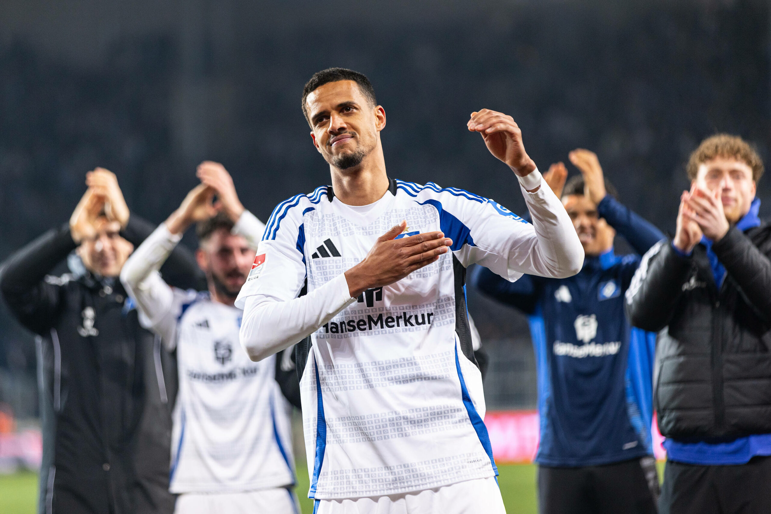 Robert Glatzel klopft sich vor der HSV-Fankurve auf die Brust