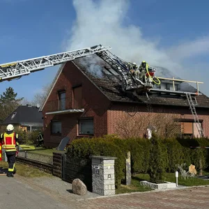 Ein brennendes Haus mit Feuerwehr