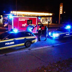 Polizisten an der Unfallstelle. Im Rettungswagen wird der Verletzte behandelt.