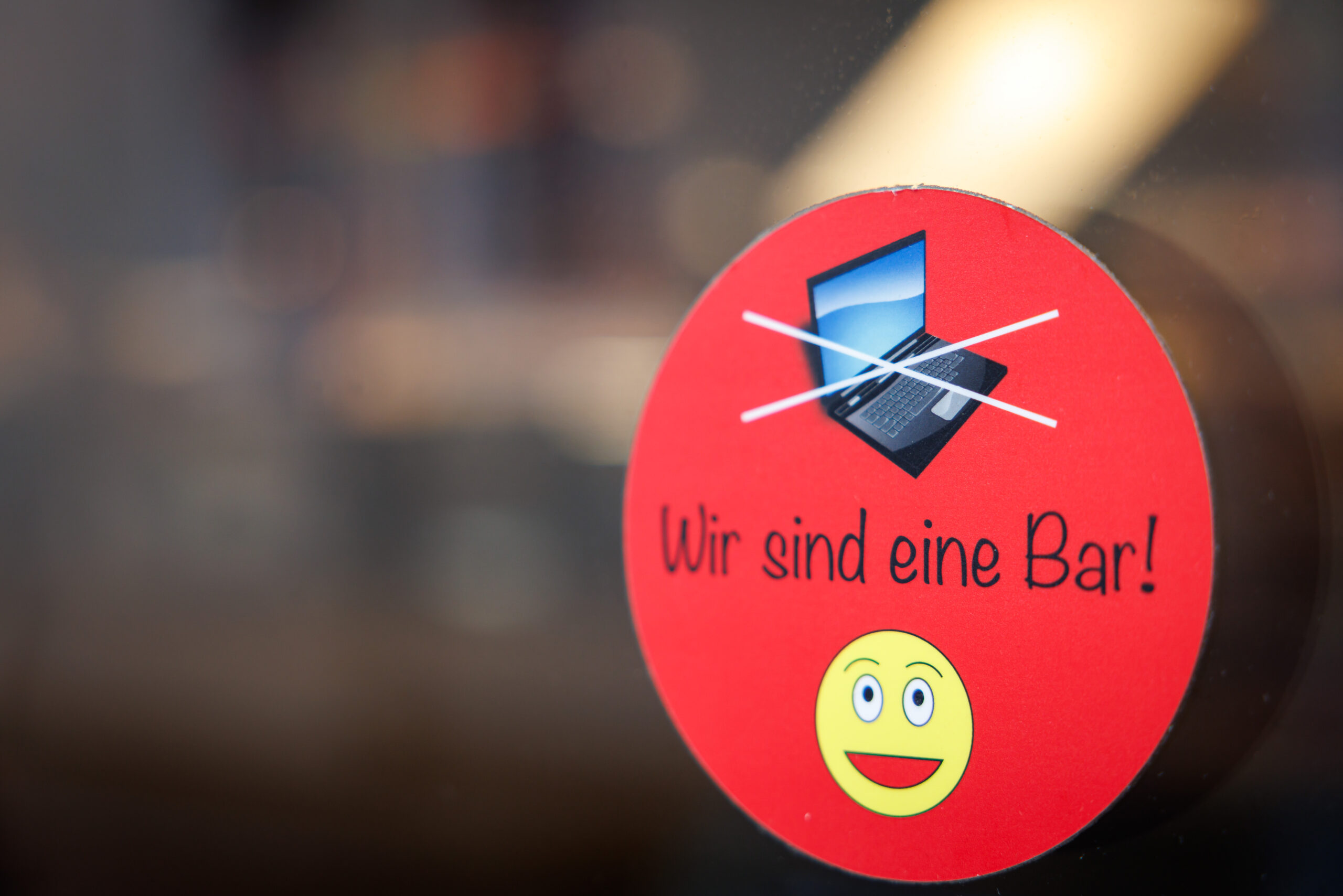 An einer Scheibe der Café-Bar 8tto Grammi weist ein Schild auf das Verbot von Laptops hin.
