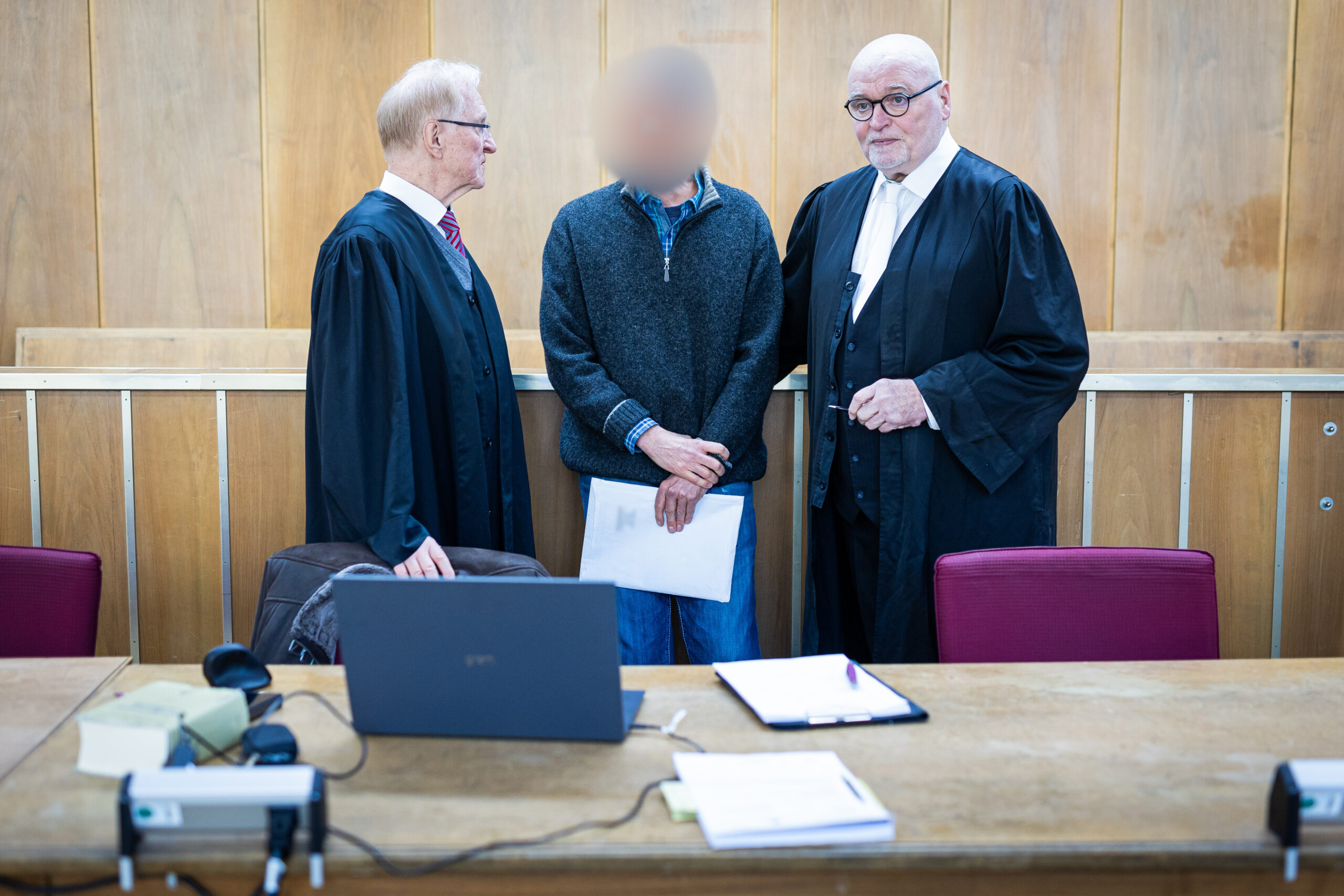 Der Angeklagte (M) steht im Gerichtssaal zwischen seinen Verteidigern Steffen Stern (l) und Matthias Waldraff (r).